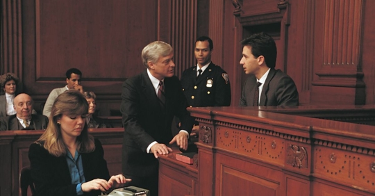 witness on stand while court stenographer types